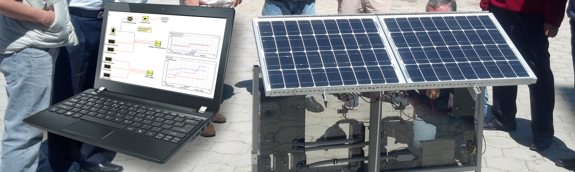 A photo of a laptop running SCADA software next to a Solar PV panel