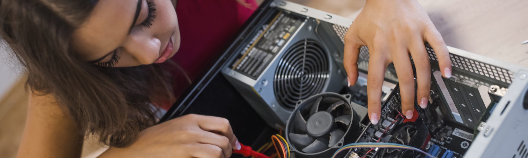 A female teen works on an open computer - building PCs from our Complete Introductory Computers Course