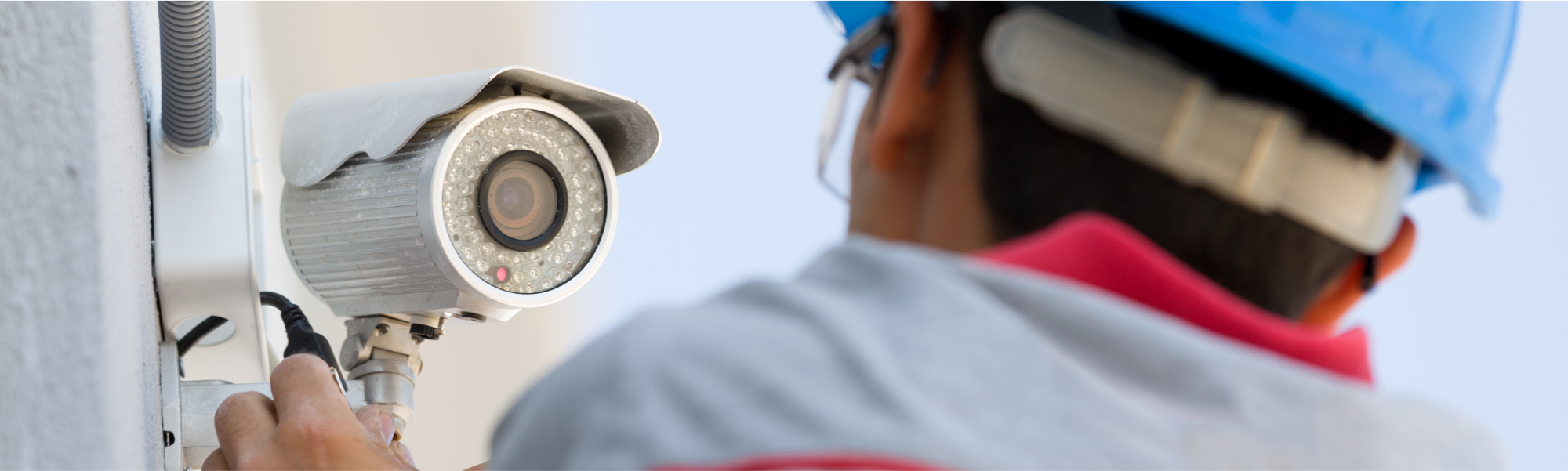 A technician installs a security camera.