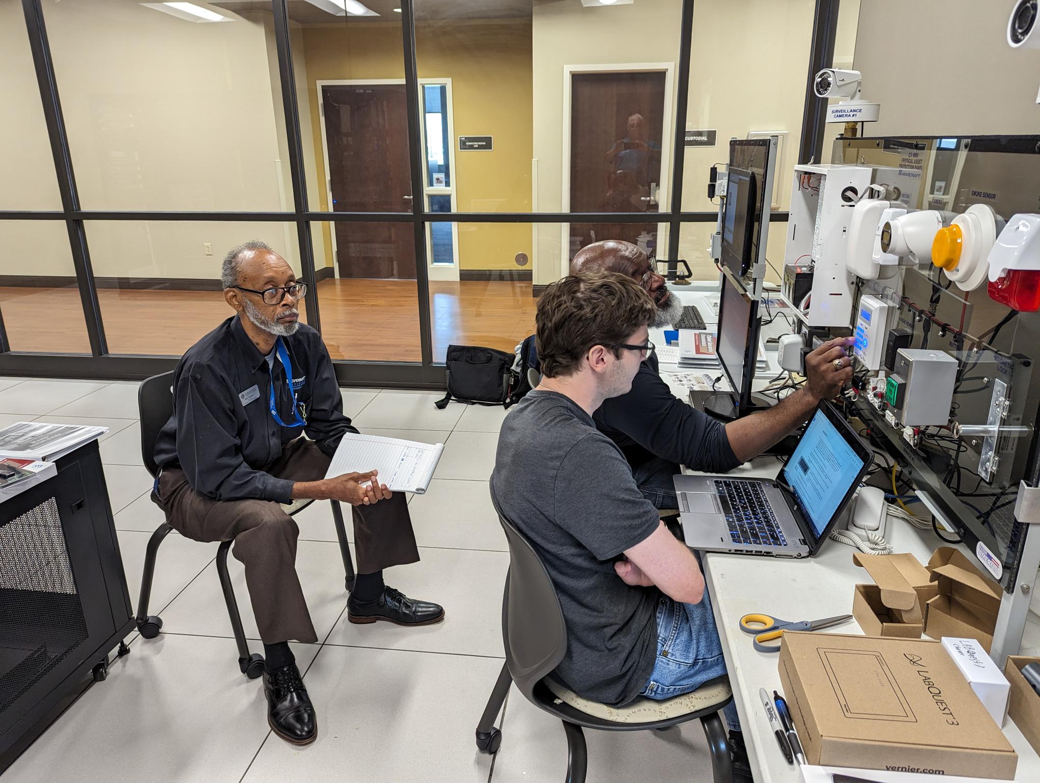 Instructors familiarizing themselves with the CS-1010 Physical Asset Protection panel.